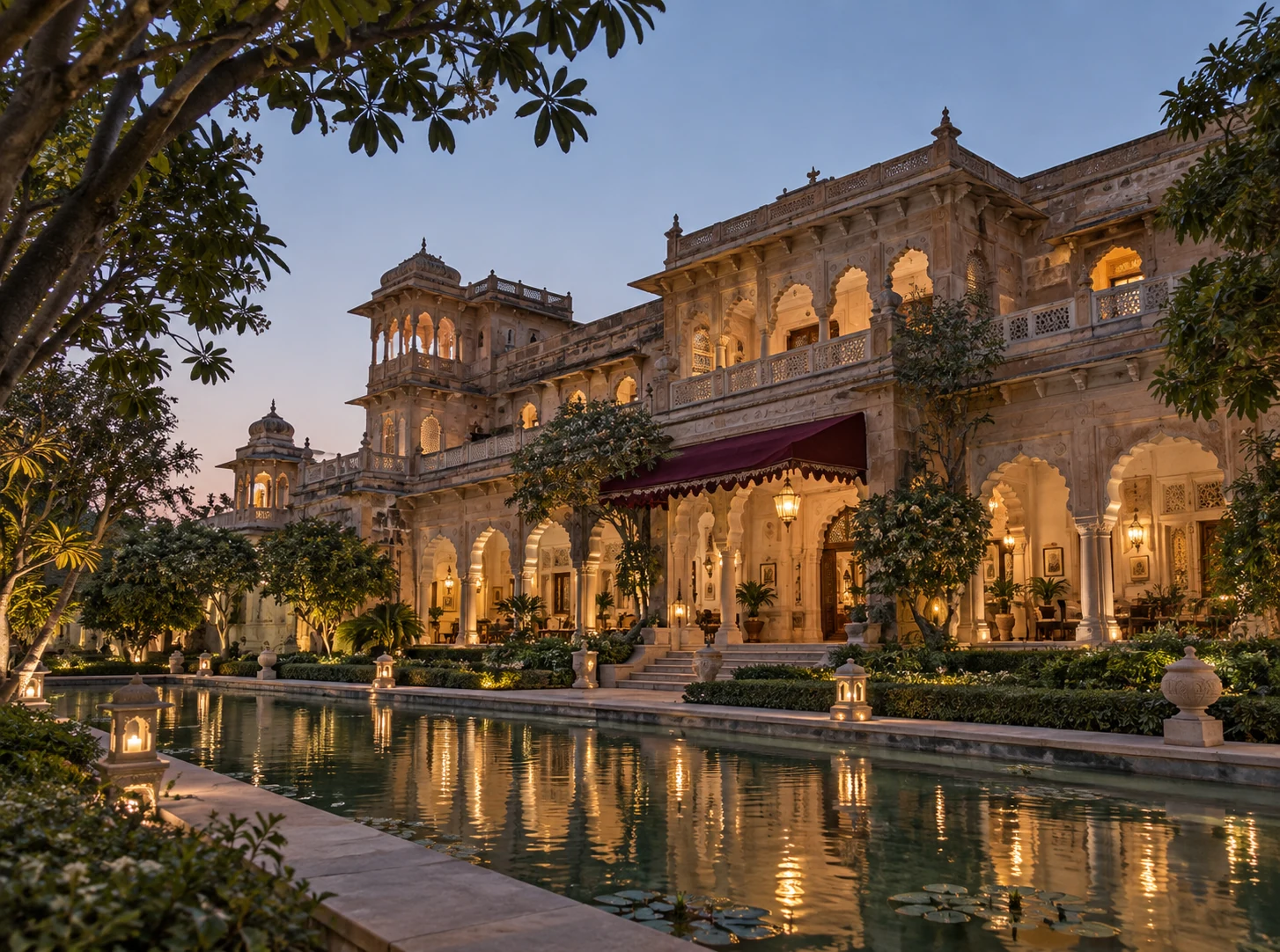 The haveli illuminated at dusk, reflected in its quiet garden pool